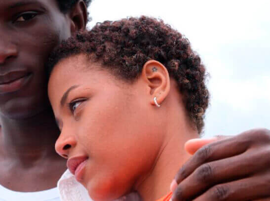 Young mixed race couple, the woman resting her head on the man's shoulder